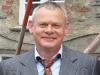 Tie loosened, smiling; not Doc Martin, surely?